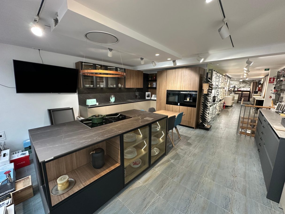 Cocina moderna con isla central, muebles de madera y electrodomésticos integrados.