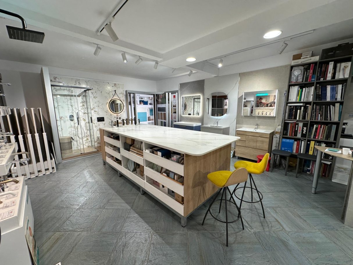Espacio moderno con una isla central, estanterías y una decoración contemporánea.