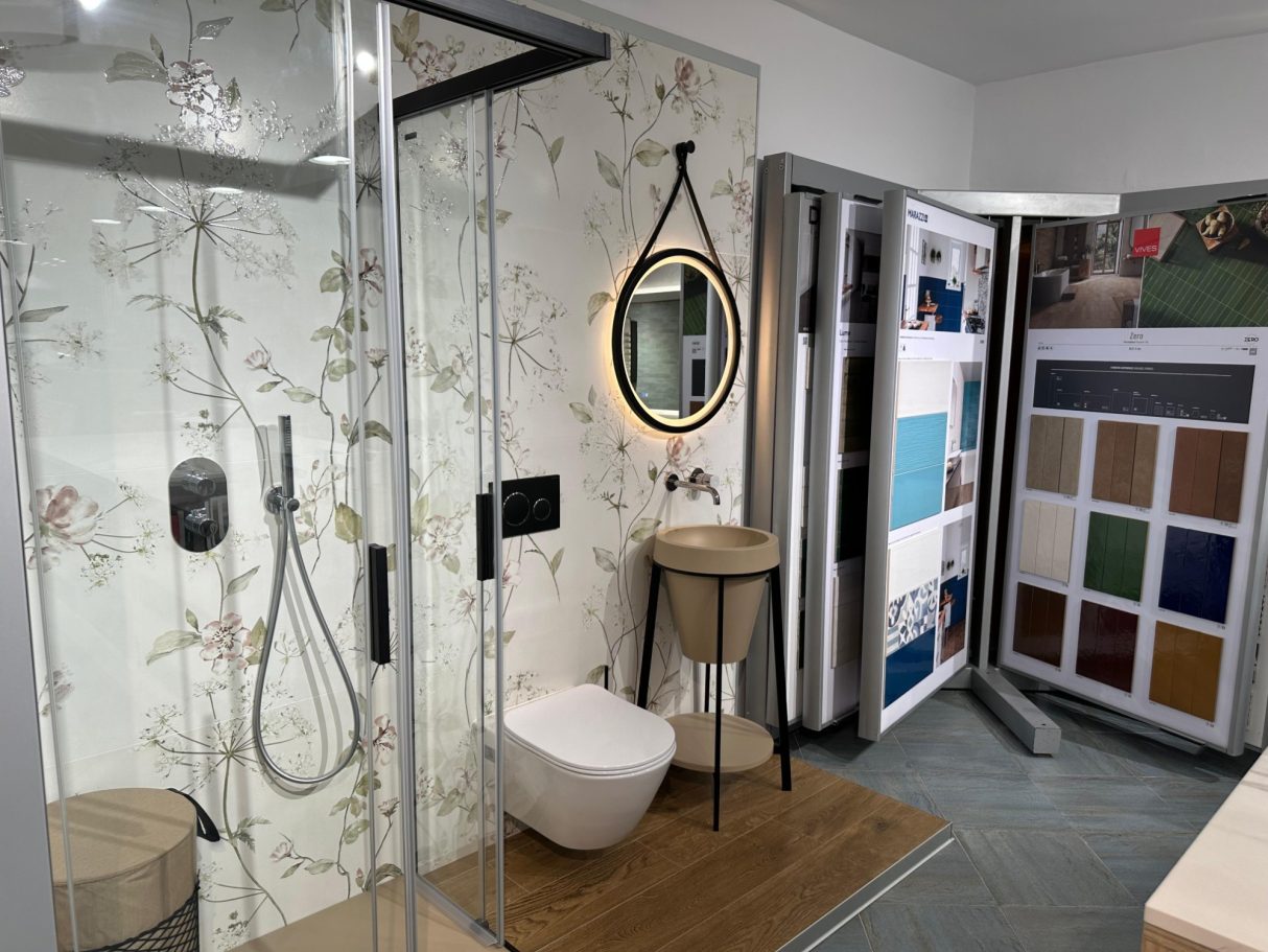 Baño moderno con ducha de cristal, inodoro, lavabo y muestrario de colores.
