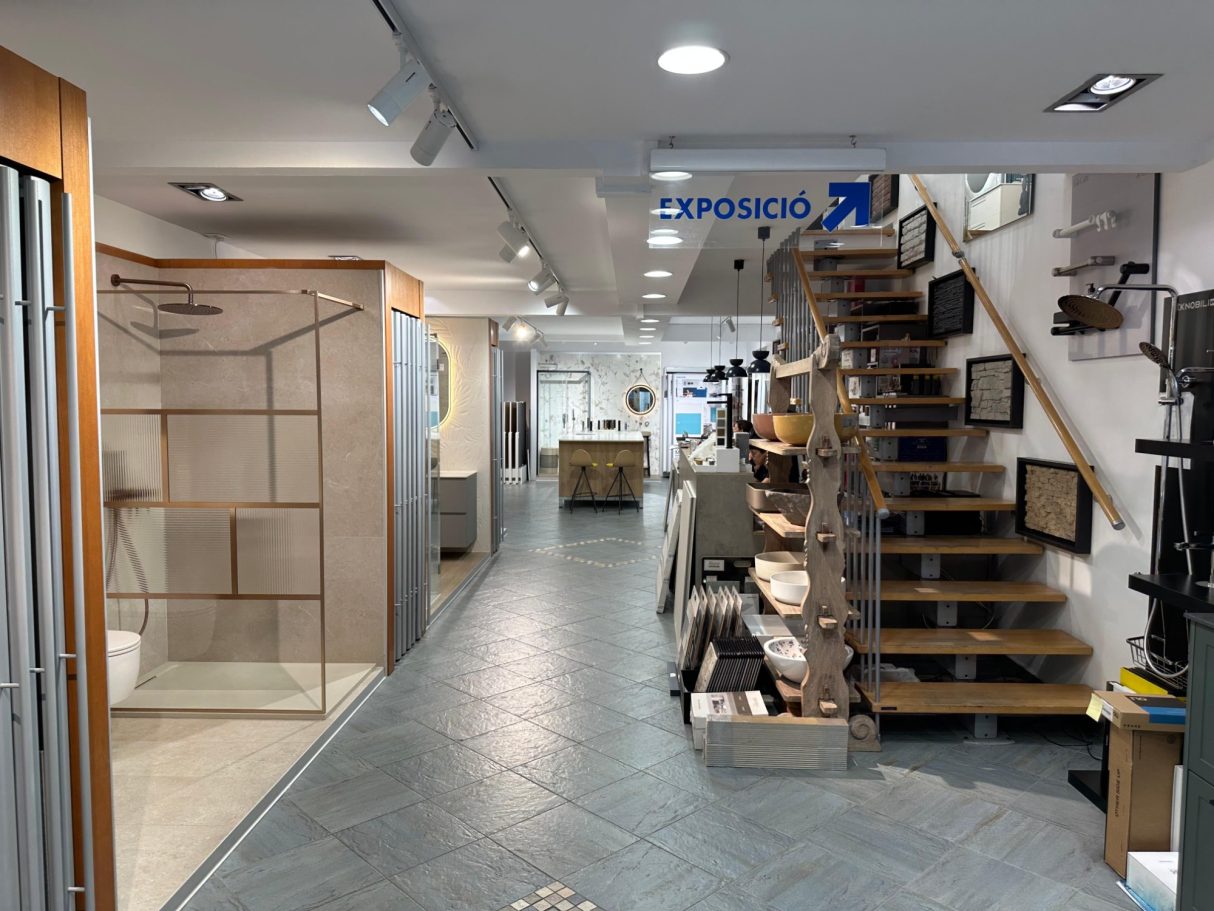 Interior de una tienda con escaleras y exhibiciones de productos de construcción.